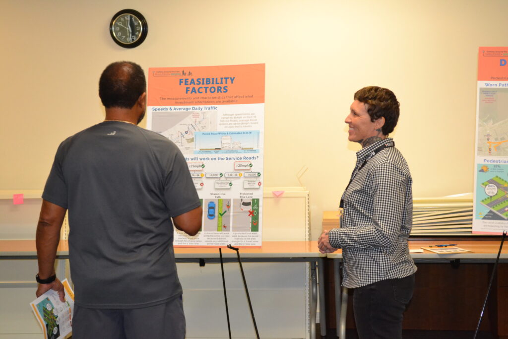 Public meeting attendees review a chart with feasibility factors